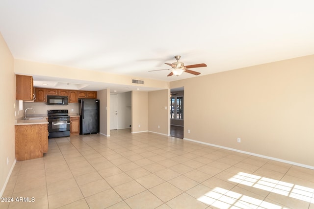 unfurnished living room with ceiling fan, sink, and light tile patterned floors