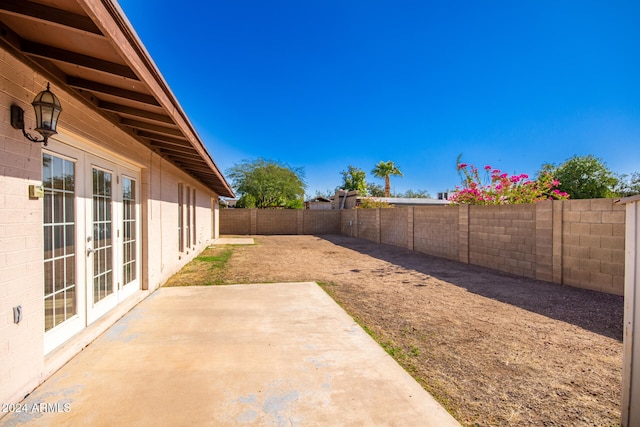 view of yard with french doors and a patio