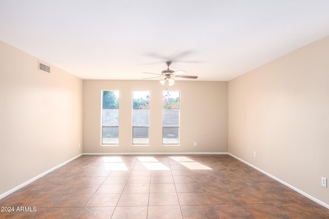 empty room featuring tile patterned floors and ceiling fan