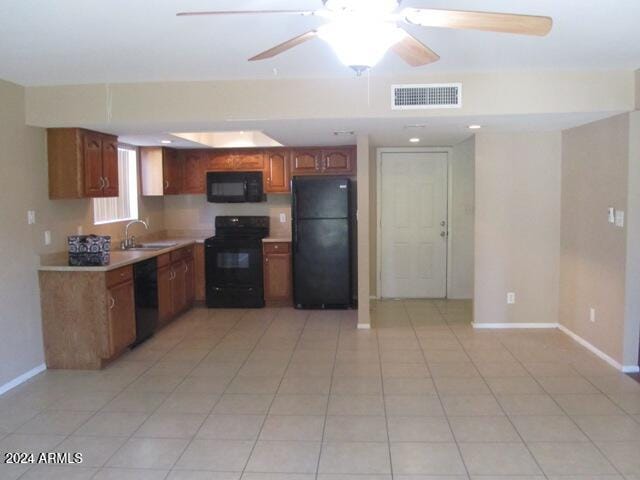 kitchen featuring ceiling fan, sink, light tile patterned floors, and black appliances