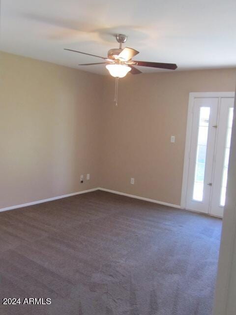 unfurnished room featuring dark carpet and ceiling fan