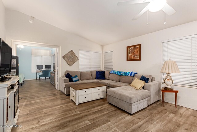 living room with hardwood / wood-style floors, ceiling fan, and vaulted ceiling