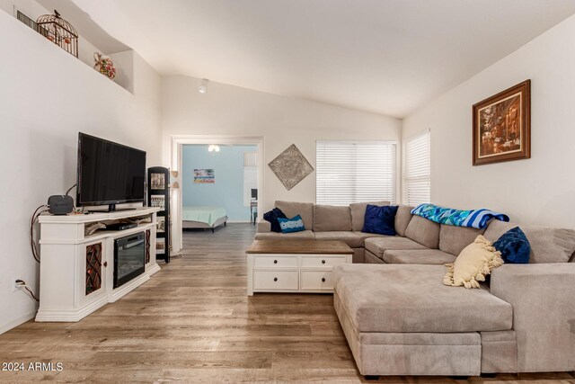 living room featuring vaulted ceiling and light wood-type flooring