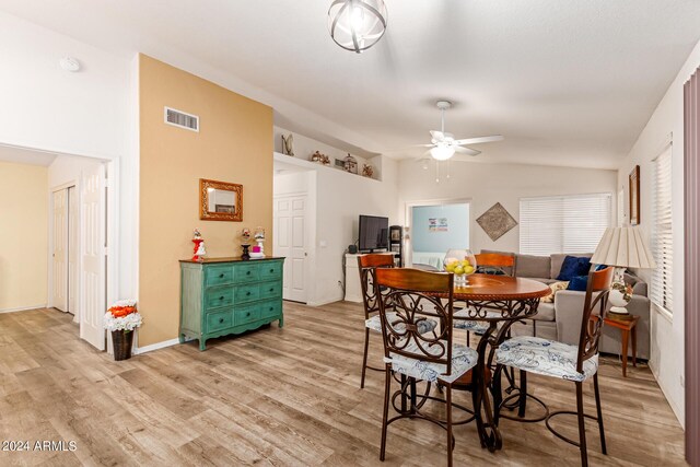 dining space featuring light wood-type flooring, lofted ceiling, and ceiling fan