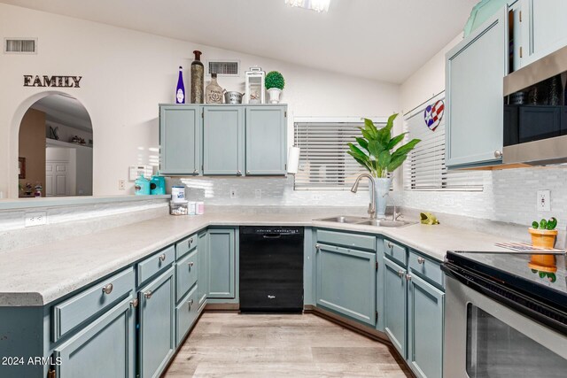 kitchen with lofted ceiling, sink, appliances with stainless steel finishes, and tasteful backsplash