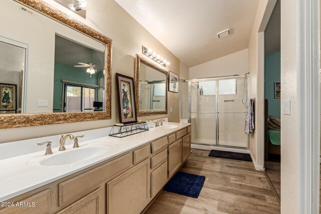 bathroom with walk in shower, hardwood / wood-style floors, vanity, ceiling fan, and lofted ceiling