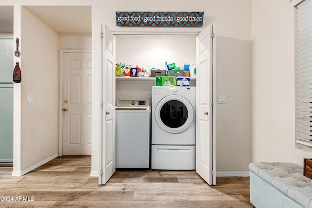 clothes washing area featuring light hardwood / wood-style flooring and separate washer and dryer