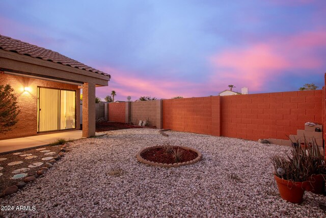 yard at dusk featuring a patio area