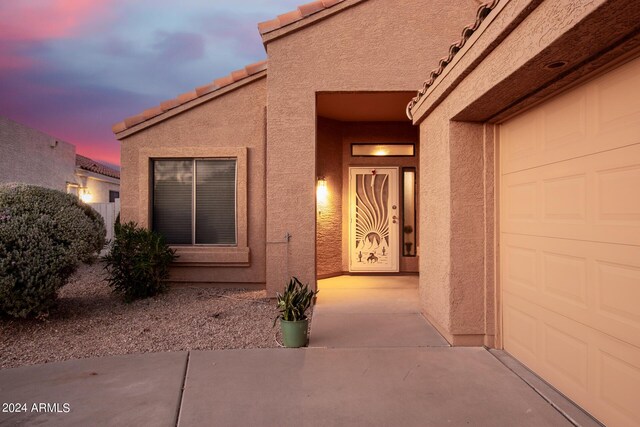 exterior entry at dusk with a garage