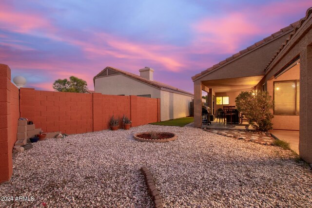 yard at dusk with a patio and an outdoor fire pit