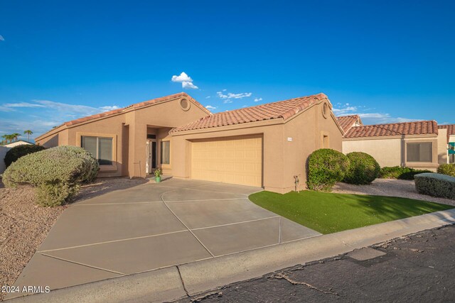 mediterranean / spanish home with a garage and a front yard