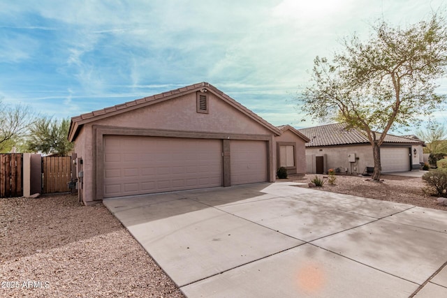 view of front of home featuring concrete driveway, an attached garage, a tiled roof, and stucco siding