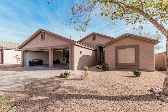 single story home with a garage, concrete driveway, and stucco siding