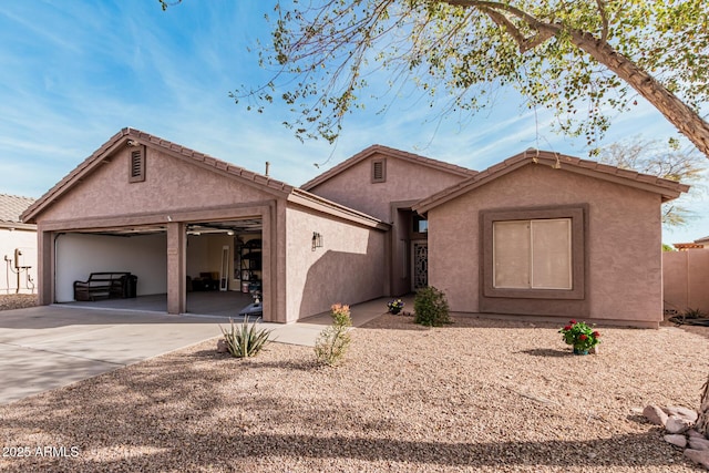 ranch-style home featuring concrete driveway, an attached garage, and stucco siding