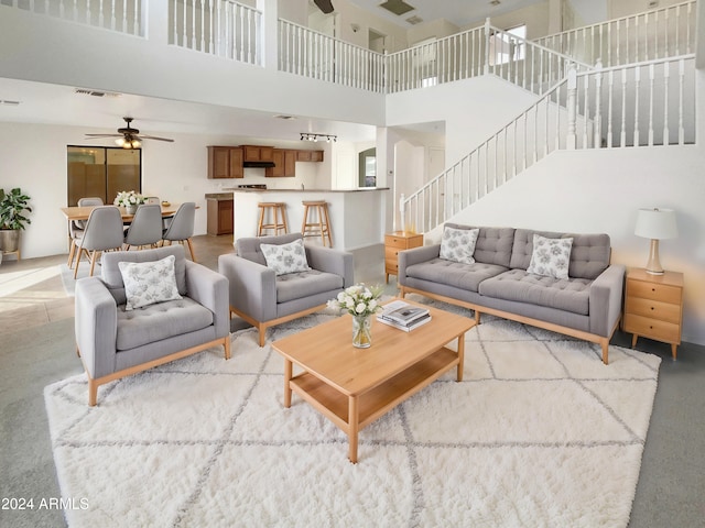 living room with a towering ceiling and ceiling fan