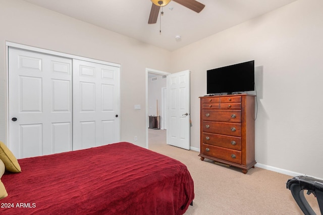 bedroom with ceiling fan, a closet, and light colored carpet