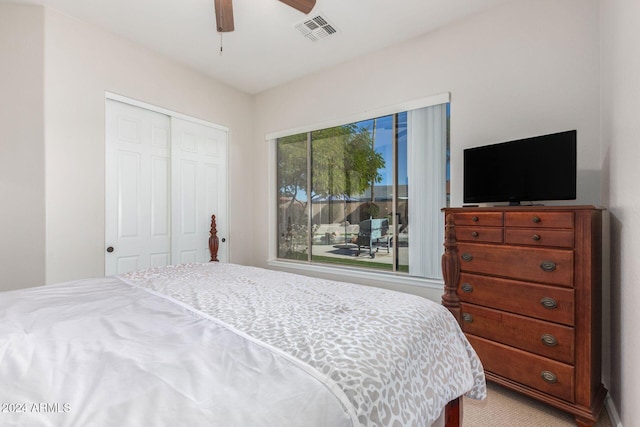 carpeted bedroom with ceiling fan and a closet