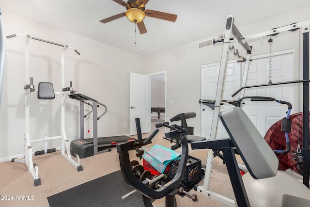 exercise area featuring ceiling fan and light colored carpet