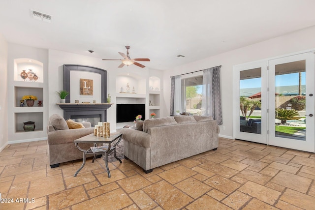 living room featuring built in shelves and ceiling fan