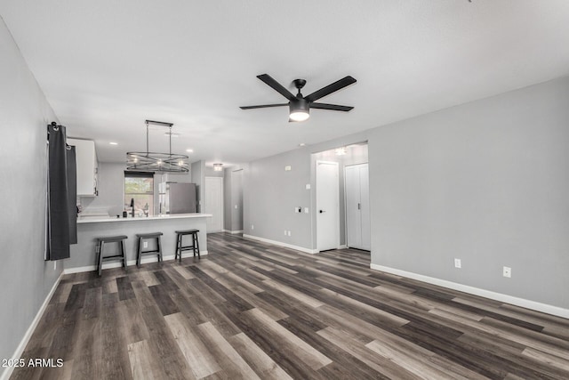 1180 W Rosal Ave, Apache Junction, AZ 85120 - unfurnished living room with baseboards, dark wood-style flooring, and a ceiling fan