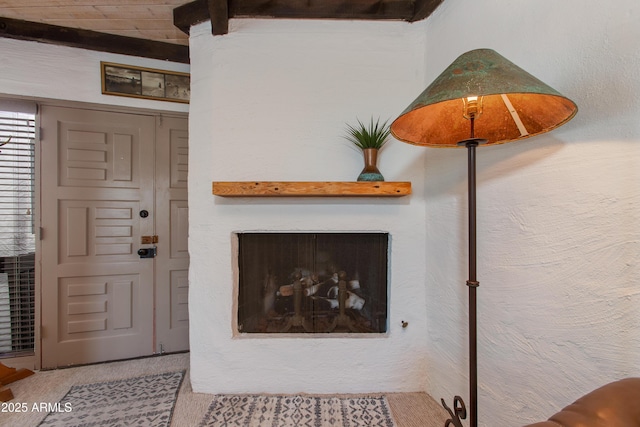 6840 E 2nd St Unit 23, Scottsdale, AZ 85251 - living area with a fireplace, beam ceiling, and carpet flooring