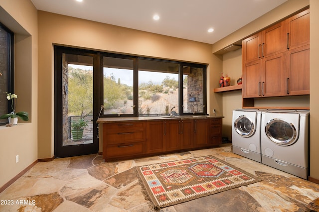 clothes washing area with cabinets, sink, separate washer and dryer, and light tile floors