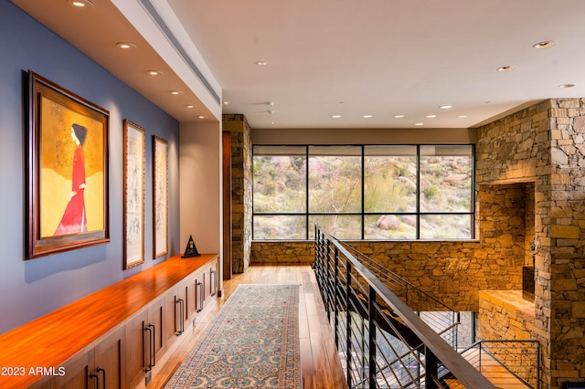 hallway with a healthy amount of sunlight and light hardwood / wood-style floors