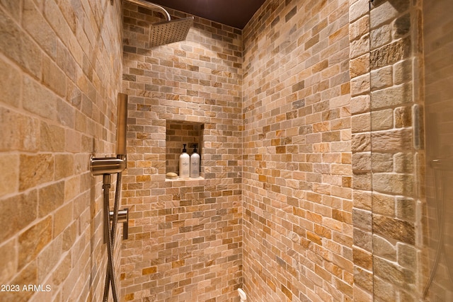 bathroom with brick wall and a shower