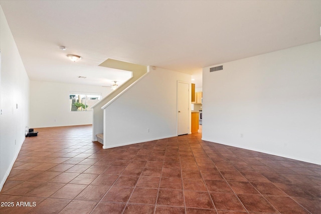 spare room with dark tile patterned floors and ceiling fan