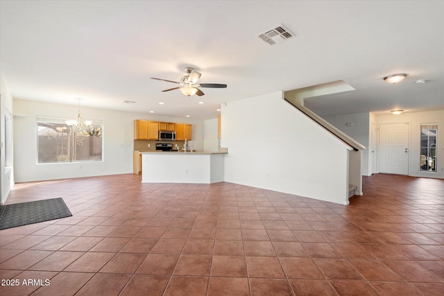 unfurnished living room with tile patterned flooring and ceiling fan with notable chandelier