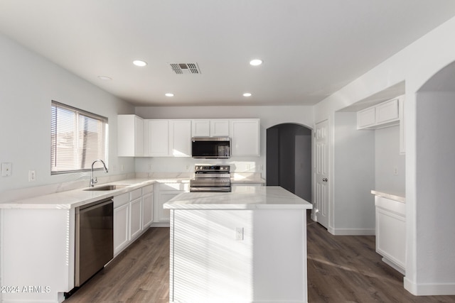 kitchen featuring stainless steel appliances, dark wood-type flooring, sink, white cabinetry, and a kitchen island