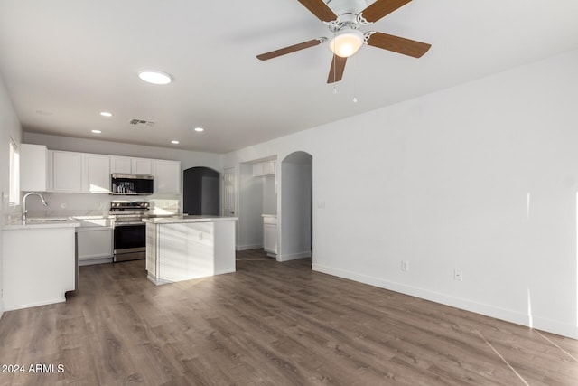 kitchen featuring stainless steel appliances, sink, wood-type flooring, white cabinets, and a kitchen island