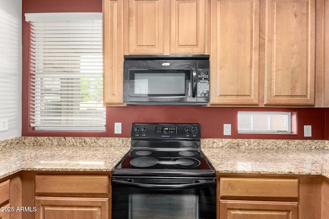 kitchen featuring black appliances and light stone countertops