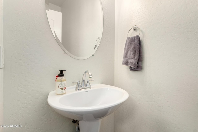 bathroom featuring a sink and a textured wall