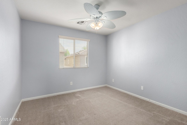 empty room featuring ceiling fan, carpet, and baseboards