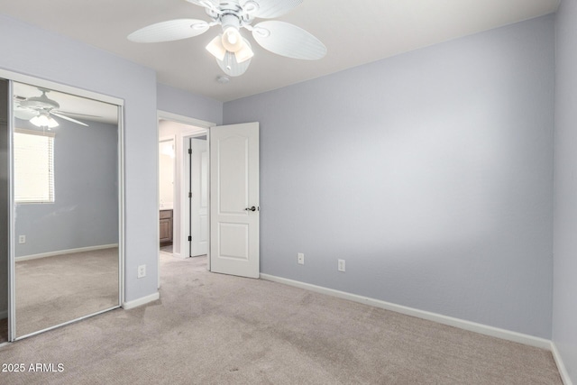 unfurnished bedroom with light carpet, a closet, baseboards, and a ceiling fan