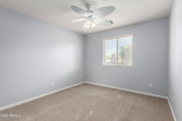 carpeted empty room featuring a ceiling fan and baseboards