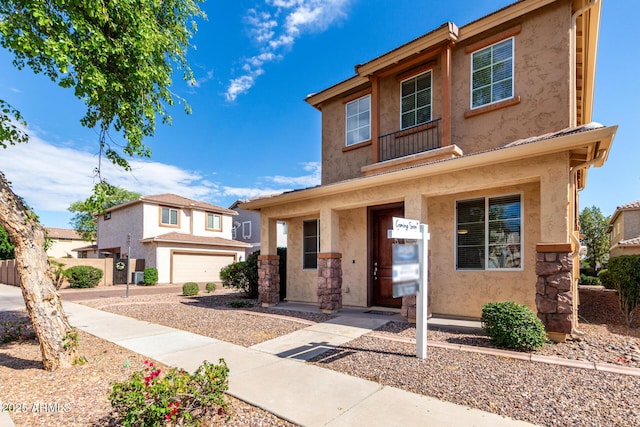 view of front of house with stucco siding, a garage, and driveway