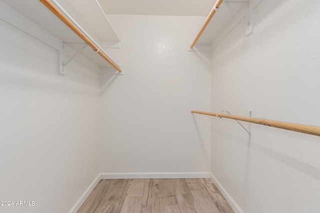 walk in closet with hardwood / wood-style flooring