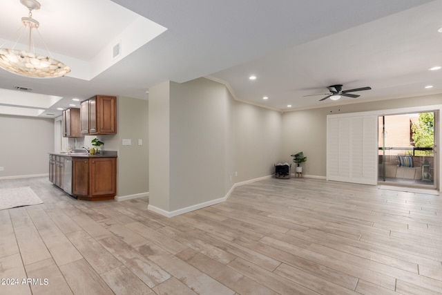 unfurnished living room featuring light wood-type flooring, ceiling fan with notable chandelier, and sink