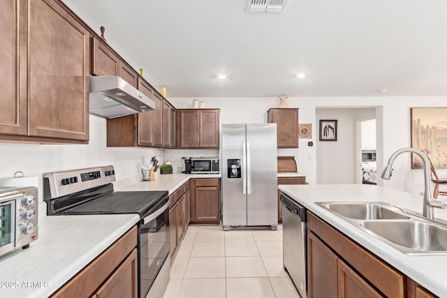 1617 W Pima Ct, Coolidge, AZ 85128 - kitchen featuring appliances with stainless steel finishes, exhaust hood, light countertops, light tile patterned floors, and recessed lighting