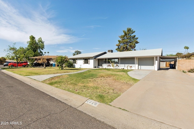 2740 N 21st Dr, Phoenix, AZ 85009 - single story home featuring concrete driveway, a front lawn, a carport, an attached garage, and a porch
