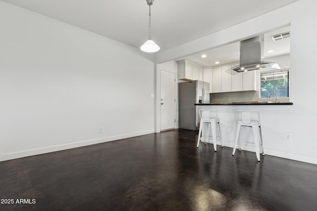 2740 N 21st Dr, Phoenix, AZ 85009 - kitchen featuring visible vents, white cabinets, stainless steel fridge, dark countertops, and island range hood