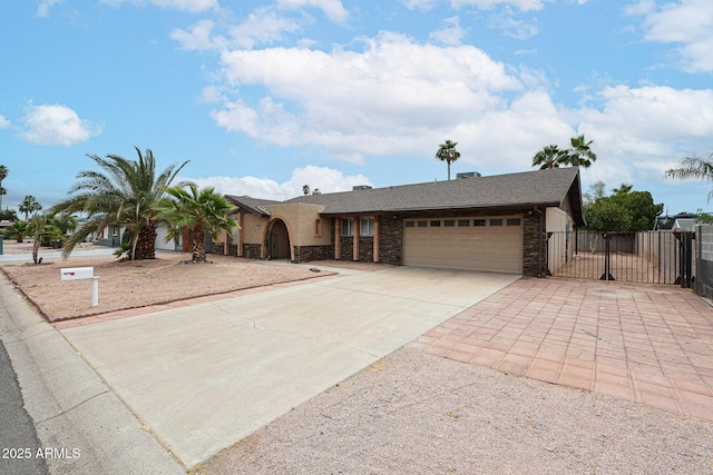 7439 E Ed Rice Ave, Mesa, AZ 85208 - view of front of home featuring driveway, an attached garage, stone siding, and a gate