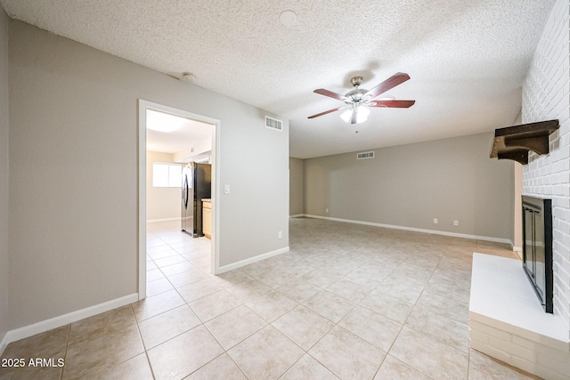 7439 E Ed Rice Ave, Mesa, AZ 85208 - unfurnished living room with ceiling fan, a brick fireplace, light tile patterned floors, a textured ceiling, and baseboards