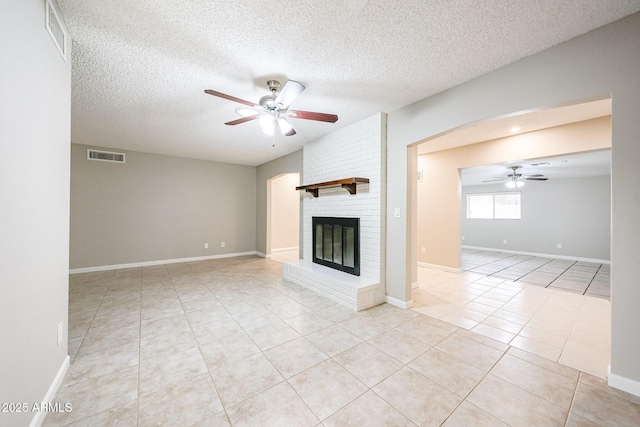 7439 E Ed Rice Ave, Mesa, AZ 85208 - unfurnished living room featuring ceiling fan, tile patterned floors, a textured ceiling, a fireplace, and baseboards