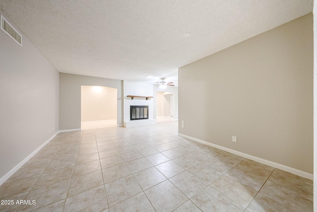 7439 E Ed Rice Ave, Mesa, AZ 85208 - unfurnished living room with ceiling fan, a textured ceiling, light tile patterned flooring, a fireplace, and baseboards