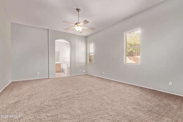 21373 N 94th Ave, Peoria, AZ 85382 - empty room featuring arched walkways, ceiling fan, light carpet, and baseboards