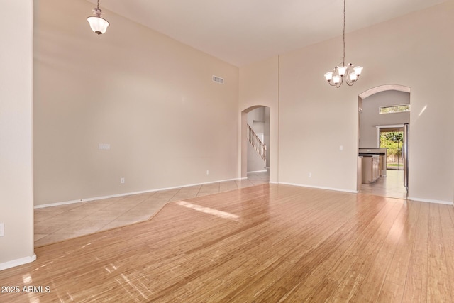 21373 N 94th Ave, Peoria, AZ 85382 - empty room with light wood-style floors, arched walkways, and a high ceiling