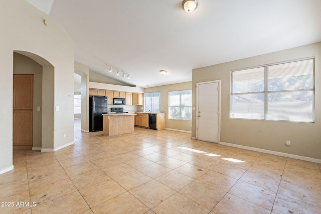 kitchen featuring light countertops, a kitchen island, vaulted ceiling, black appliances, and baseboards